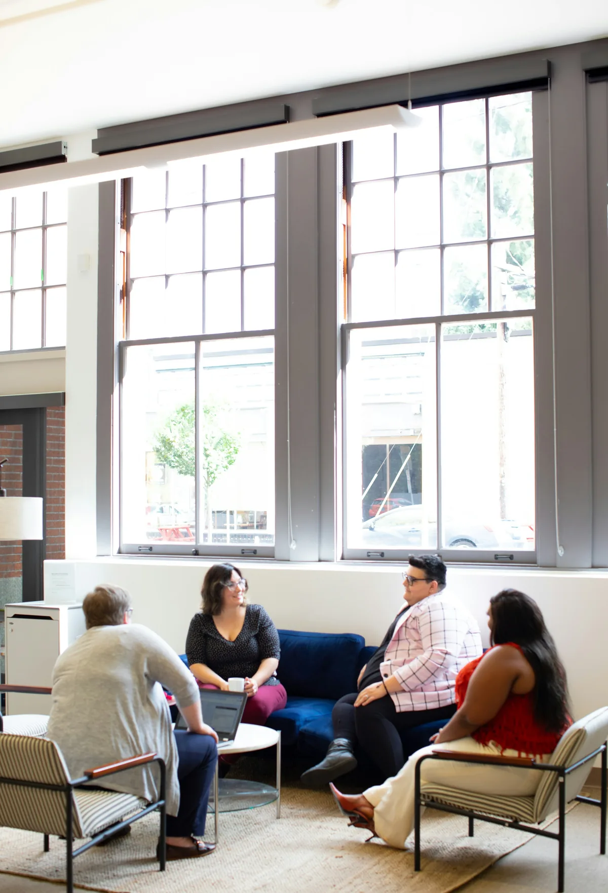 Four people seated in conversation in a bright room