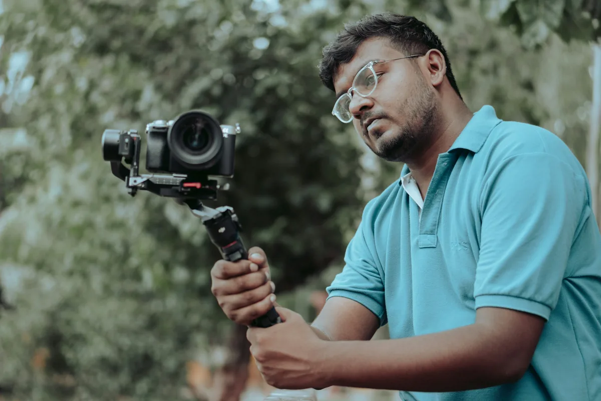 A young man filming with a camera on a handheld stabiliser