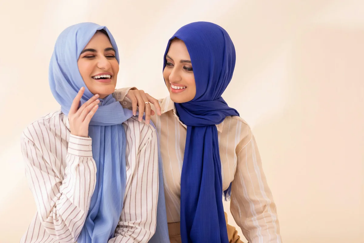 Two friends in headscarves laughing together