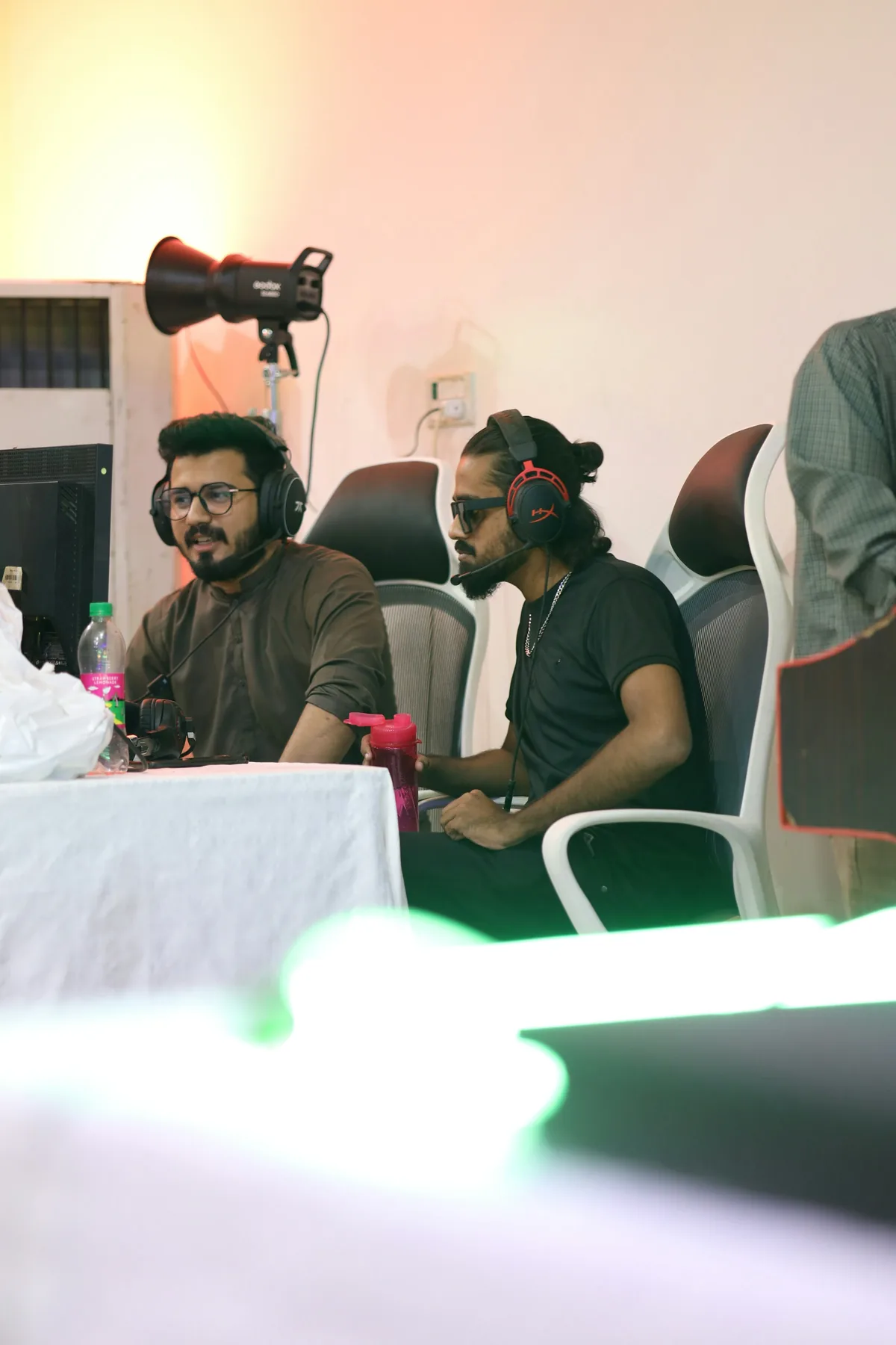 Two men in conversation at a table during a recording session