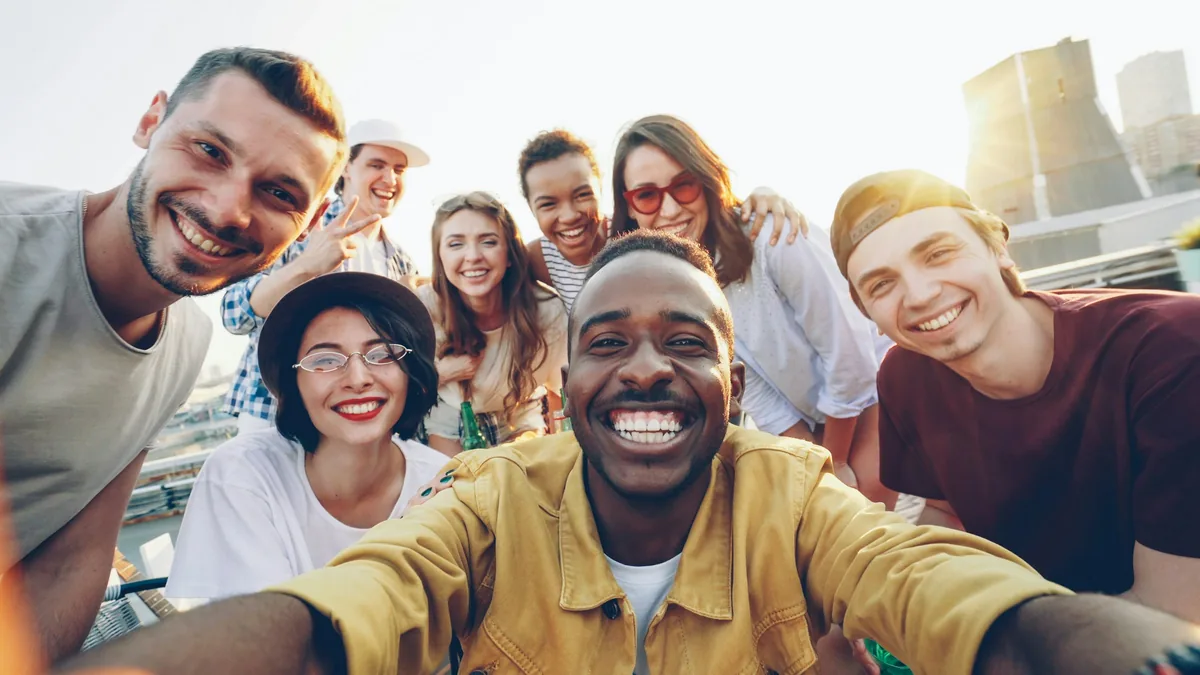 A diverse group of friends smiling together for a photograph outdoors