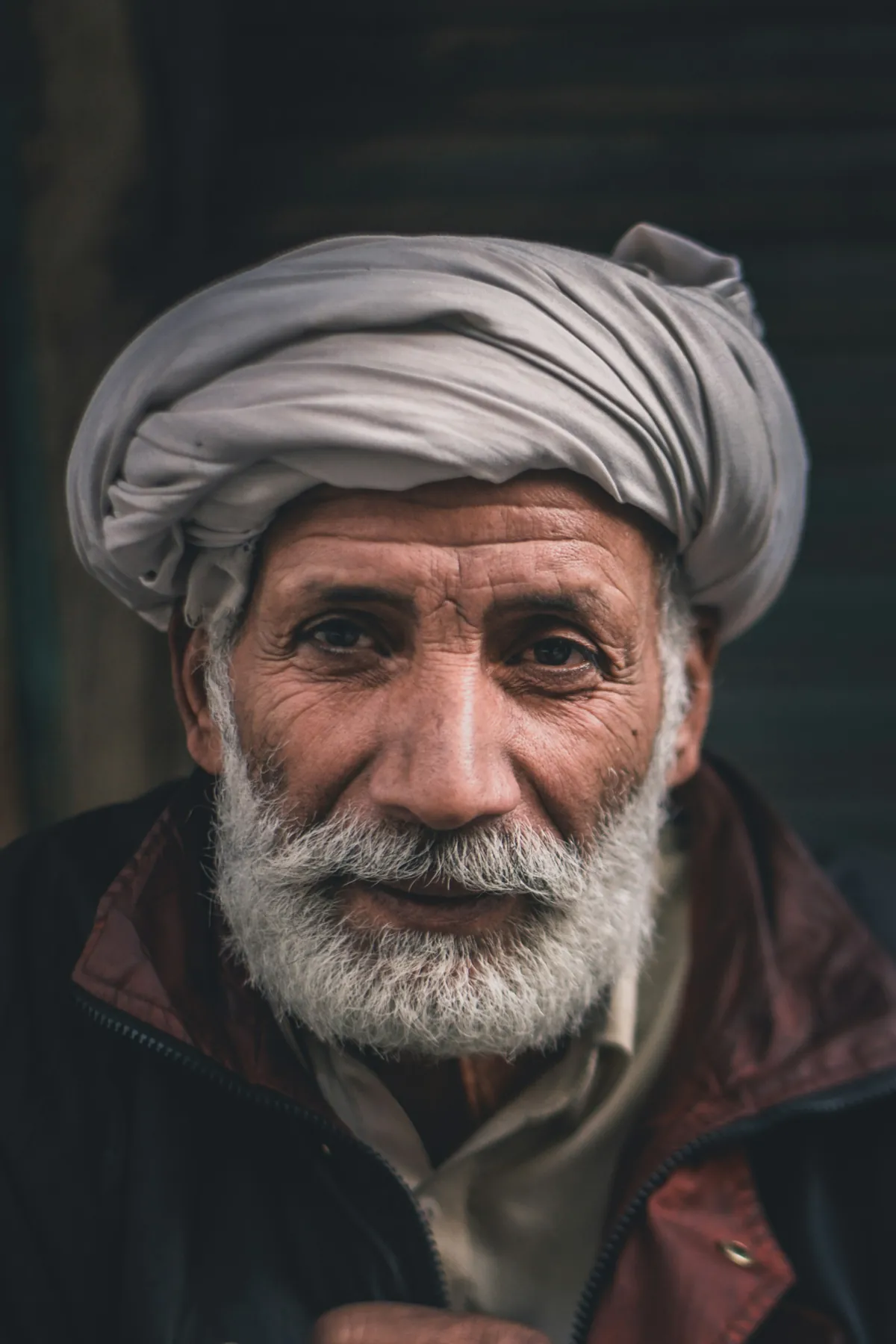 An older Pakistani man in a turban, looking warmly towards the camera