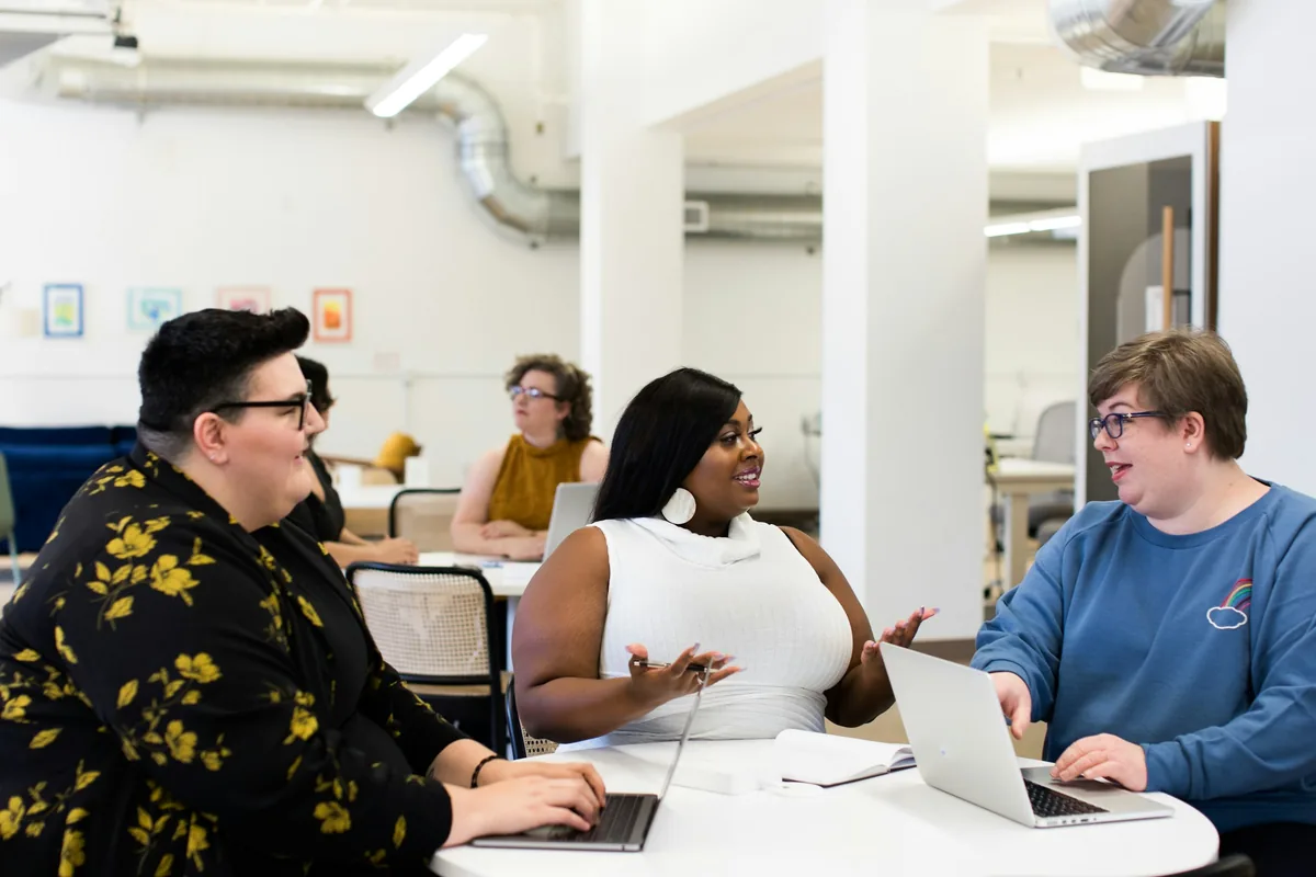 Colleagues talking around a table in a bright office